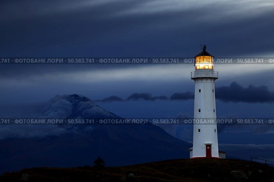 Cape Egmont Lighthouse and Taranaki Mount on background, New Zealand. Стоковое фото, агентство Ingram Publishing / Фотобанк Лори