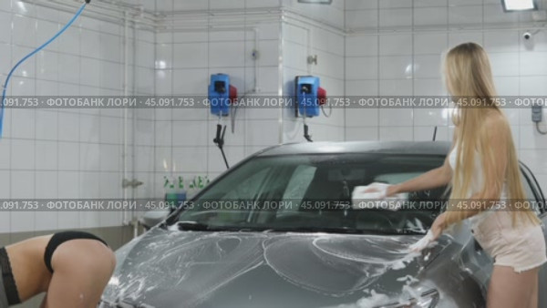 Car Wash. Three Sexy young beautiful girls in a car wash, indoor. Стоковое видео, видеограф Андрей Аркуша / Фотобанк Лори