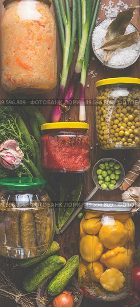 Carious pickled colorful vegetables in jars on wooden background with ingredients, herbs and spices. Copy space. Mock up. Harvest preserving. Fermented  food. Canned vegetables . Top view. Стоковое фото, агентство Ingram Publishing / Фотобанк Лори