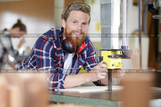 carpenter adjusting blade on bench saw. Стоковое фото, агентство Ingram Publishing / Фотобанк Лори