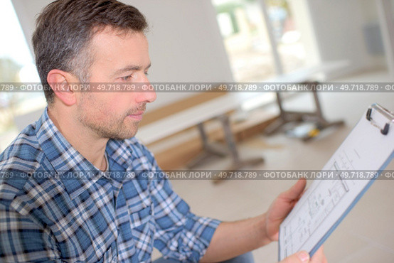 Carpenter looking at his clipboard. Стоковое фото, агентство Ingram Publishing / Фотобанк Лори