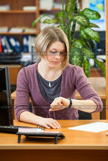 Casual clothes businesswoman watching the time before importrant meeting or conference while sitting in office room. Стоковое фото, фотограф Кекяляйнен Андрей / Фотобанк Лори