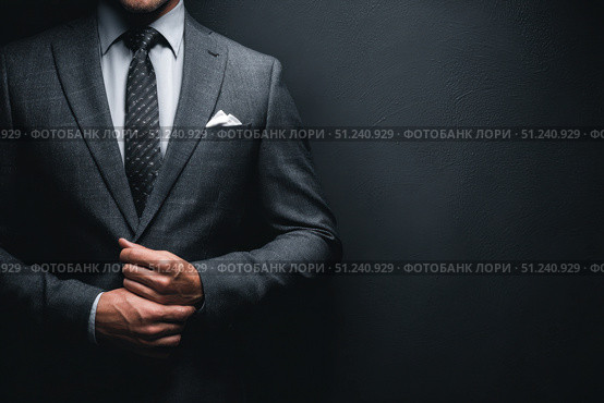 Caucasian businessman in a formal wear isolated on a dark gray background. Confident man in suit standing over black wall. Business concept. Mature executive manager, proud lawyer, successful leader. Стоковое AI-изображение, AI-художник Марина Демидюк / Фотобанк Лори