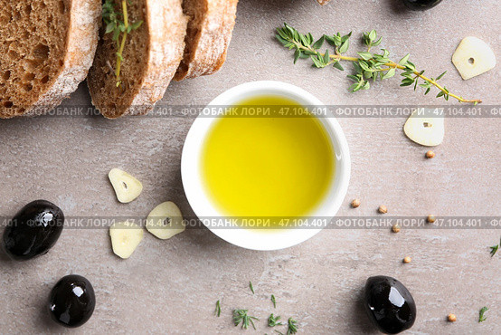 Чаша с маслом, маслинами и хлебом на сером фоне, вид сверху. Стоковое фото, фотограф Pixel_shot / Фотобанк Лори