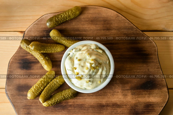 Чаша с вкусным соусом тартар и маринованными огурцами на деревянном фоне. Стоковое фото, фотограф Pixel_shot / Фотобанк Лори