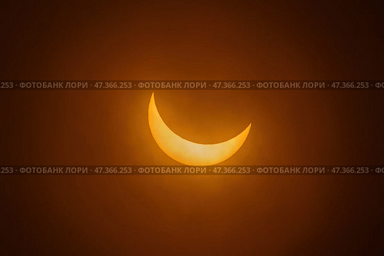 Частичное солнечное затмение. Серп солнца на темном небе. Стоковое фото, фотограф Сергей Богомяко / Фотобанк Лори