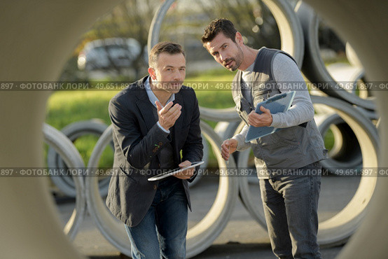 checking asbestos pipes for drain in construction site. Стоковое фото, агентство Ingram Publishing / Фотобанк Лори