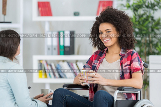 cheerful lady in wheelchair with cup of tea. Стоковое фото, агентство Ingram Publishing / Фотобанк Лори