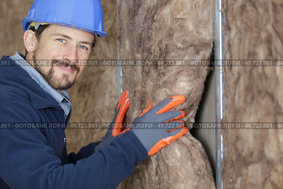 cheerful plasterer worker at a indoors wall insulation works. Стоковое фото, агентство Ingram Publishing / Фотобанк Лори