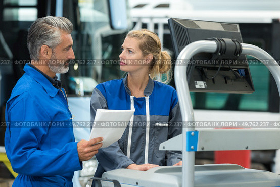 cheerful superviser and female worker at repair shop. Стоковое фото, агентство Ingram Publishing / Фотобанк Лори