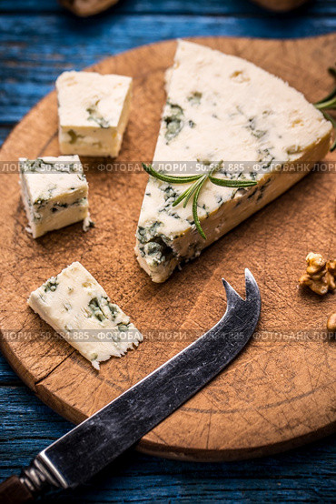 Cheese with mold on wooden cutting board. Стоковое фото, агентство Ingram Publishing / Фотобанк Лори