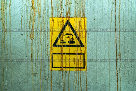 Chemical warnings sign on a wall with fluids leaking down the metal surface. Стоковое фото, агентство Ingram Publishing / Фотобанк Лори
