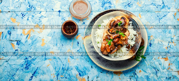 Chicken meat with mushroom sauce on a rice pad. Stewed meat with Sicilian marsala sauce. Copy space. Meat with marsala sauce and white rice. Стоковое фото, агентство Ingram Publishing / Фотобанк Лори