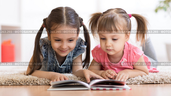 Child girl reading book with little sister at home. Стоковое фото, фотограф Оксана Кузьмина / Фотобанк Лори