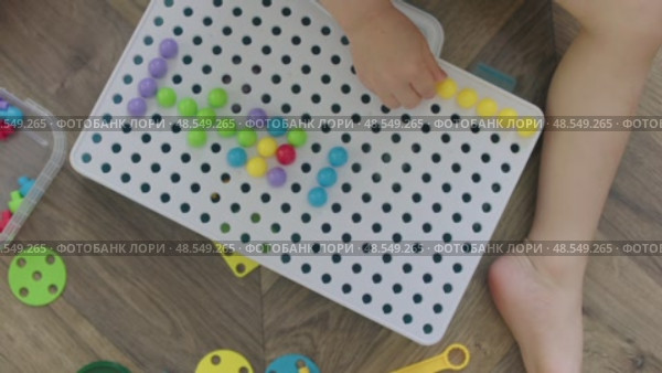 child playing with mosaic pins designing picture forms, motor skills putting pin. Стоковое видео, видеограф Olesia Kondrateva / Фотобанк Лори