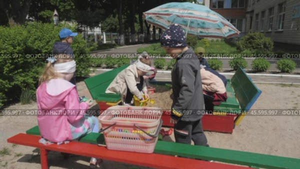 Children, boys and girls in kindergarten play in sand with toys on the street. Kids on the playground in sandbox on sunny day: Gomel, Belarus - June 2021. Редакционное видео, видеограф Дмитрий Нечаев / Фотобанк Лори
