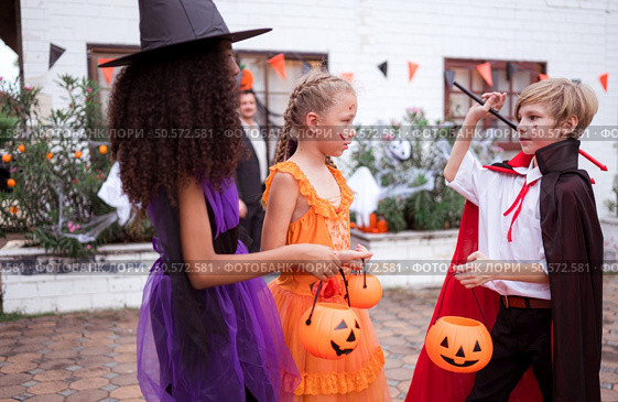 Children in ghost costumes are having fun trick-or-treating on Halloween. Стоковое фото, агентство Ingram Publishing / Фотобанк Лори