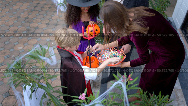 Children in ghost costumes are having fun trick-or-treating on Halloween. Стоковое фото, агентство Ingram Publishing / Фотобанк Лори