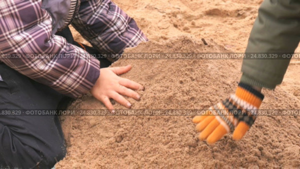 Children playing with sand in outdoor sandbox. Стоковое видео, видеограф worker / Фотобанк Лори