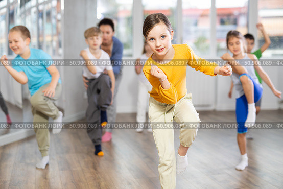 Children studying modern style dances with female teacher in dance class. Стоковое фото, фотограф Яков Филимонов / Фотобанк Лори
