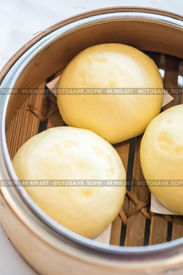 Chinese dim sum yolk lava Bun - Steamed Chinese groumet cuisine. Стоковое фото, агентство Ingram Publishing / Фотобанк Лори