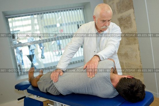 chiropractor examine the patient's spine. Стоковое фото, агентство Ingram Publishing / Фотобанк Лори