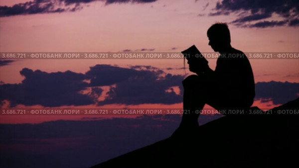 Читающий подросток на закате. Стоковое видео, видеограф Losevsky Pavel / Фотобанк Лори