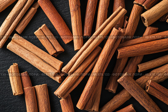 Cinnamon background. Pile of cinnamons stick top view. Cinnamomum cassia close up. Spice for the Holidays. Assortment of spices. Cinnamon bark is a spice used for sweet and savory dish. Стоковое AI-изображение, AI-художник Марина Демидюк / Фотобанк Лори