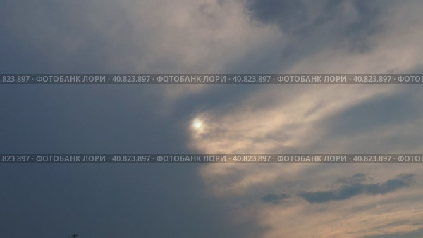 Cirrus clouds cover the disk of the sun with clouds. The disappearance of the sun behind thick dark clouds. Sunbeams in the haze. Sunset for Halloween. Weather forecast. Sky background. Стоковое видео, видеограф Юлия Петровская / Фотобанк Лори
