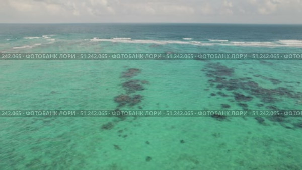 Clear turquoise sea water with patches of reef viewed from above on sunny day. Стоковое видео, видеограф Igor Tichonow / Фотобанк Лори