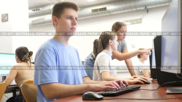Clever focused male teenager solving tasks of computer science in the auditory. Стоковое видео, видеограф Яков Филимонов / Фотобанк Лори