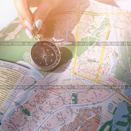 close up female s hand holding navigational compass map. Стоковое фото, агентство Ingram Publishing / Фотобанк Лори