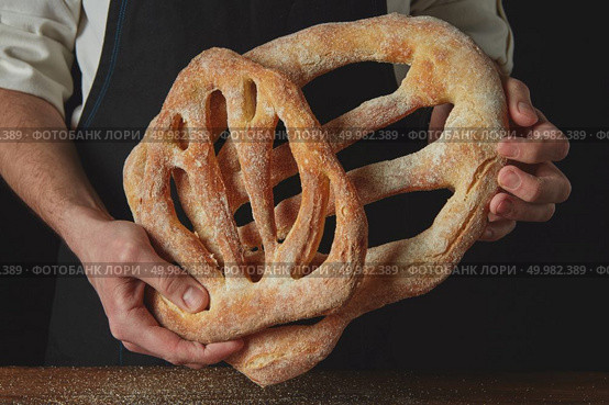 Close-up of a baker hands with fougas bread. Baker is holding fougas bread. Стоковое фото, агентство Ingram Publishing / Фотобанк Лори