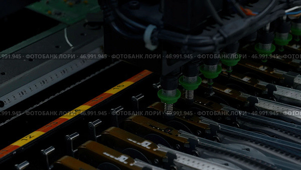 Close up of details of automatic SMD pick and place machine during work. Стоковое фото, фотограф David Kashakhi / Фотобанк Лори