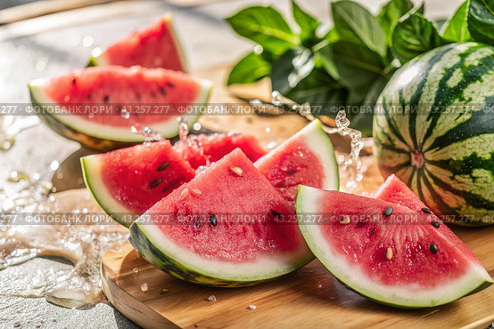Close-up of fresh watermelon berries. Delicious berries and fruits of bright red color with drops of water. Vegetarianism. Healthy eating. Fresh fruits on the table. Стоковое AI-изображение, AI-художник Photojuli / Фотобанк Лори