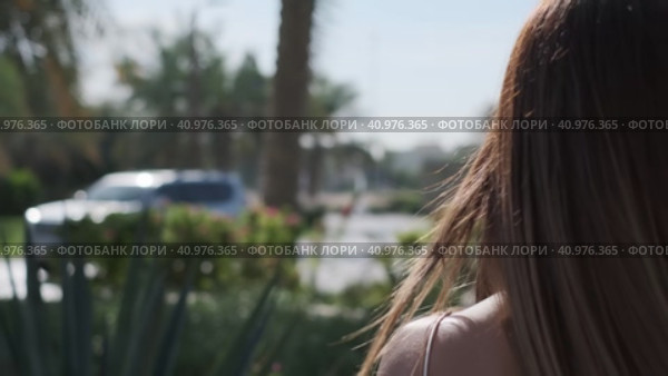 Close-up of long hair of a young girl walking through a tropical garden. Стоковое видео, видеограф Aleksey Kidisyuk / Фотобанк Лори