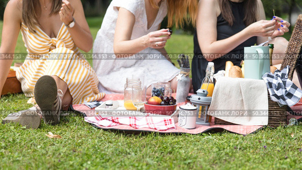 close up women sitting green grass enjoying picnic. Стоковое фото, агентство Ingram Publishing / Фотобанк Лори