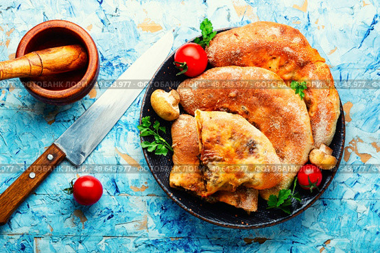 Closed pizza with mushrooms. Calzone - Italian pie. Calzone - Italian pie, pizza. Стоковое фото, агентство Ingram Publishing / Фотобанк Лори