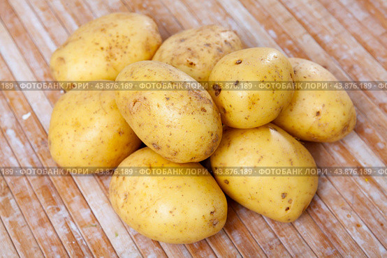 Closeup of fresh organic yellow potatoes on wooden table. Стоковое фото, фотограф Яков Филимонов / Фотобанк Лори