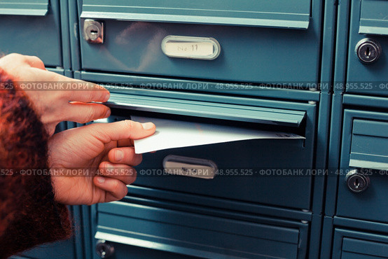 Closeup on afemale hand putting a letter in a letterbox. Стоковое фото, агентство Ingram Publishing / Фотобанк Лори