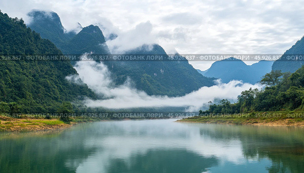 Clouds embracing green mountains over the river in cao bang, vietnam. Стоковое AI-изображение, AI-художник Юрий Поздников / Фотобанк Лори