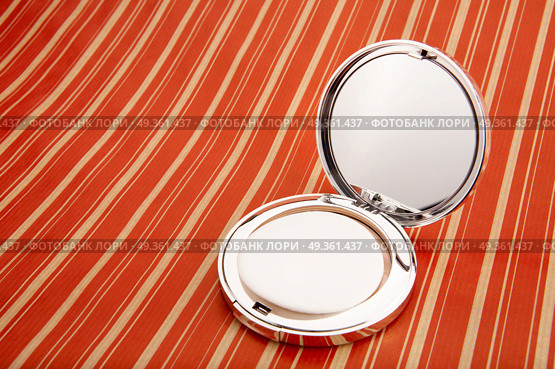 Collapsible mirror on a bright background. Small mirror. Стоковое фото, агентство Ingram Publishing / Фотобанк Лори