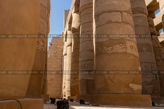 Colonnade in the hypostyle hall of the Karnak Temple. Rows of columns in close-up against the blue sky. Hieroglyphs and carvings are visible. Egypt. Luxor (2021 год). Стоковое фото, фотограф Вера Ивановна Кубарева / Фотобанк Лори