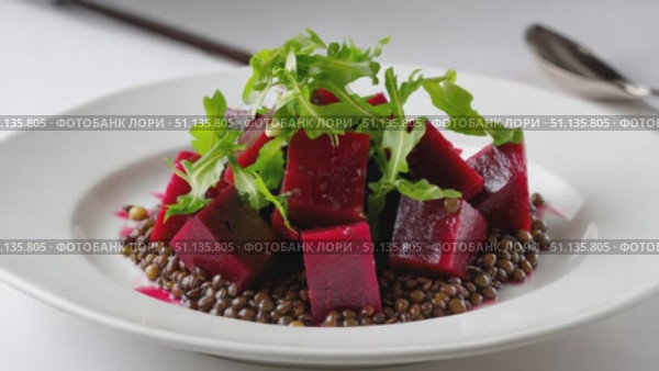 Colorful beetroot salad mixing lentils, arugula, resting on crisp white plate, representing healthy gourmet vegetarian cuisine. Стоковое AI-видео, аниматор Юрий Поздников / Фотобанк Лори