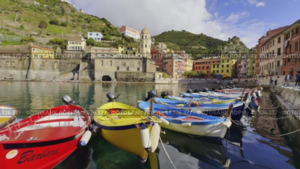 Colorful boats docked in Vernazza harbor with scenic buildings and hills around. Редакционное видео, видеограф Антон Гвоздиков / Фотобанк Лори
