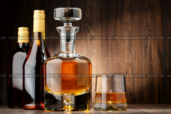 Composition with bottles of assorted alcoholic beverages and glass of whisky. Стоковое фото, агентство Ingram Publishing / Фотобанк Лори