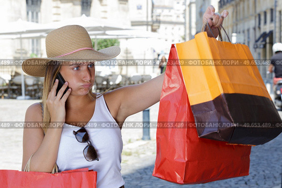 compulsive shopper sighing as she looks at her shopping bags. Стоковое фото, агентство Ingram Publishing / Фотобанк Лори