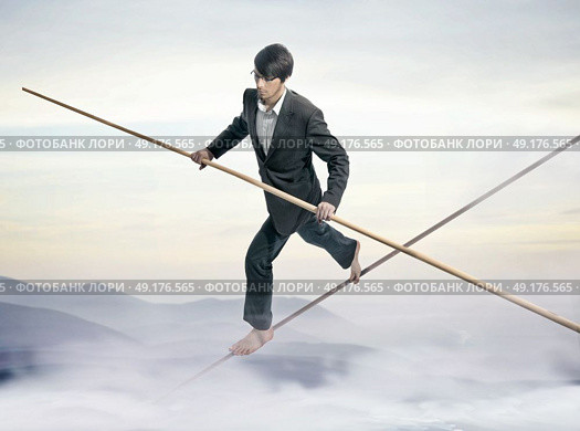 Conceptual picture of a young businessman - slackliner. Стоковое фото, агентство Ingram Publishing / Фотобанк Лори