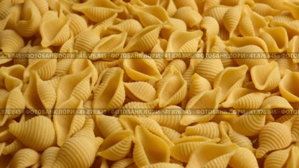 Conchiglie, Shells or Seashells Pasta Wallpaper. Spiral Raw Macaroni from Wheat flour rotating on Turntable. Close Up Top View. Uncooked Pasta Spinning. Full Frame. Food Background. Conchigliette. Стоковое видео, видеограф Марина Демидюк / Фотобанк Лори