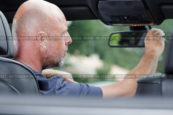 confident man looking into the rearview mirror. Стоковое фото, агентство Ingram Publishing / Фотобанк Лори